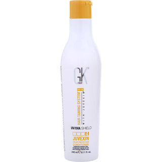 Gk Hair PRO LINE HAIR TAMING SYSTEM WITH JUVEXIN COLOR PROTECTION MOISTURIZING SHAMPOO 33.8 OZ bottle on an elegant bathroom counter.