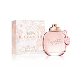 Coach Floral Perfume bottle placed in front of its stylish box, showcasing the chic and sophisticated design of both the bottle and packaging. Available at fragrancedealz.com.